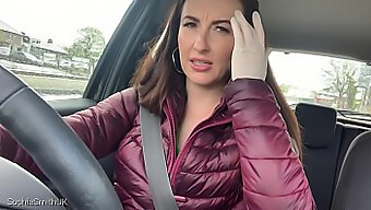 A Brunette Woman In Medical Attire Drives A Car And Pedals While Wearing Gloves