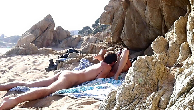 Man and woman engage in oral and vaginal sex outdoors on the beach